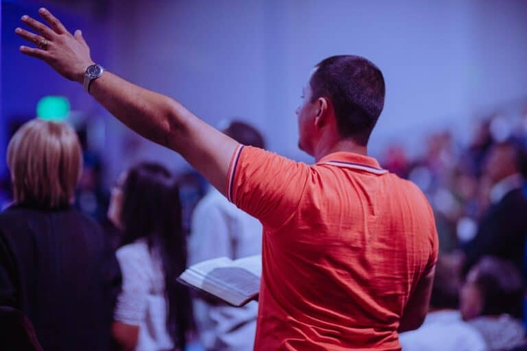 man holding Bible praising the Lord